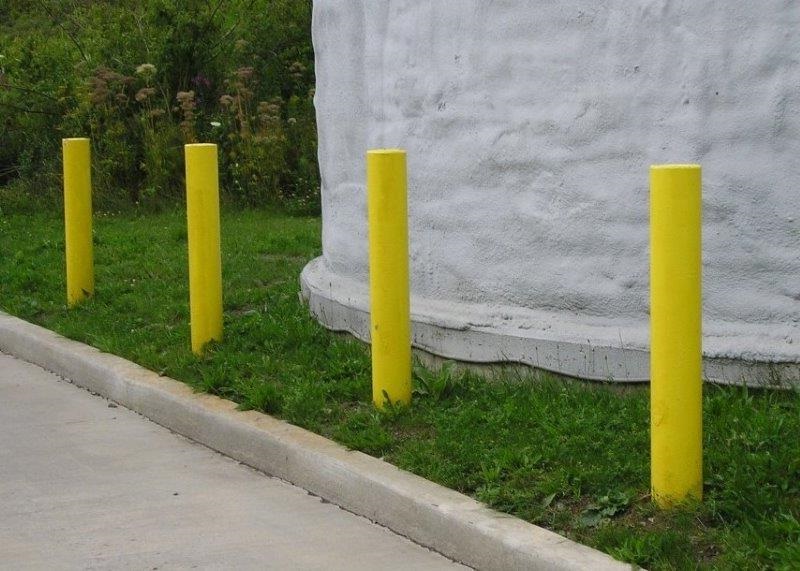 Yellow Painted Metal and Concrete Bollards